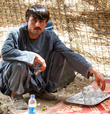 An Afghan Uniform Police (AUP) officer serves tea at a checkpoint in Panjwai, April 2013. Photo by Bill Ardolino